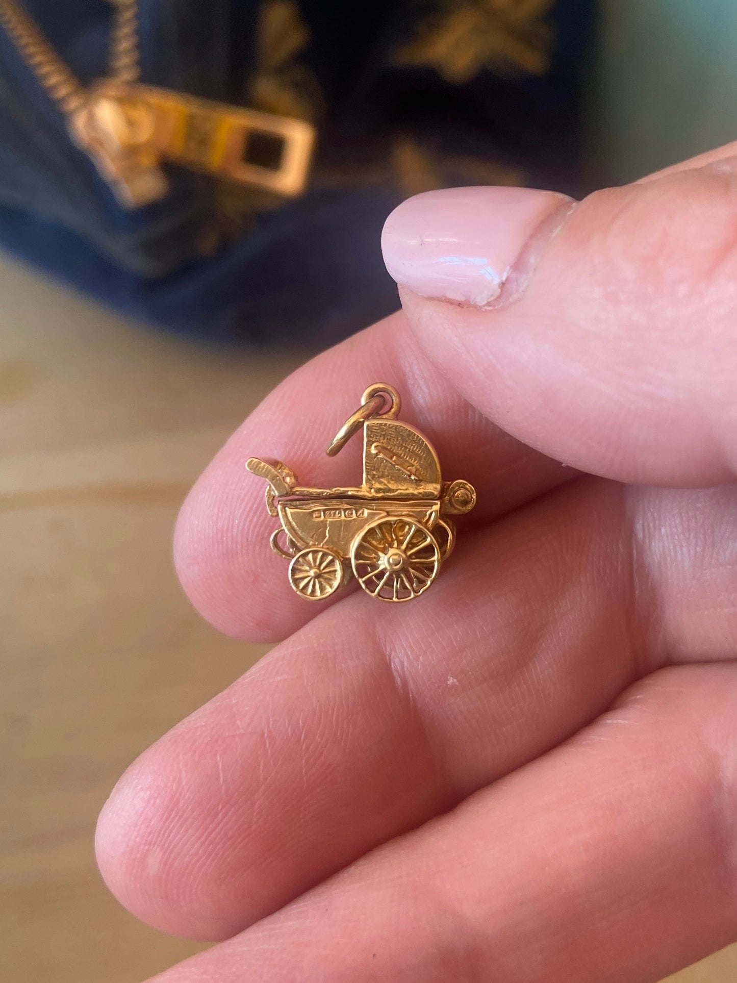 9ct vintage opening pram charm with baby inside.
